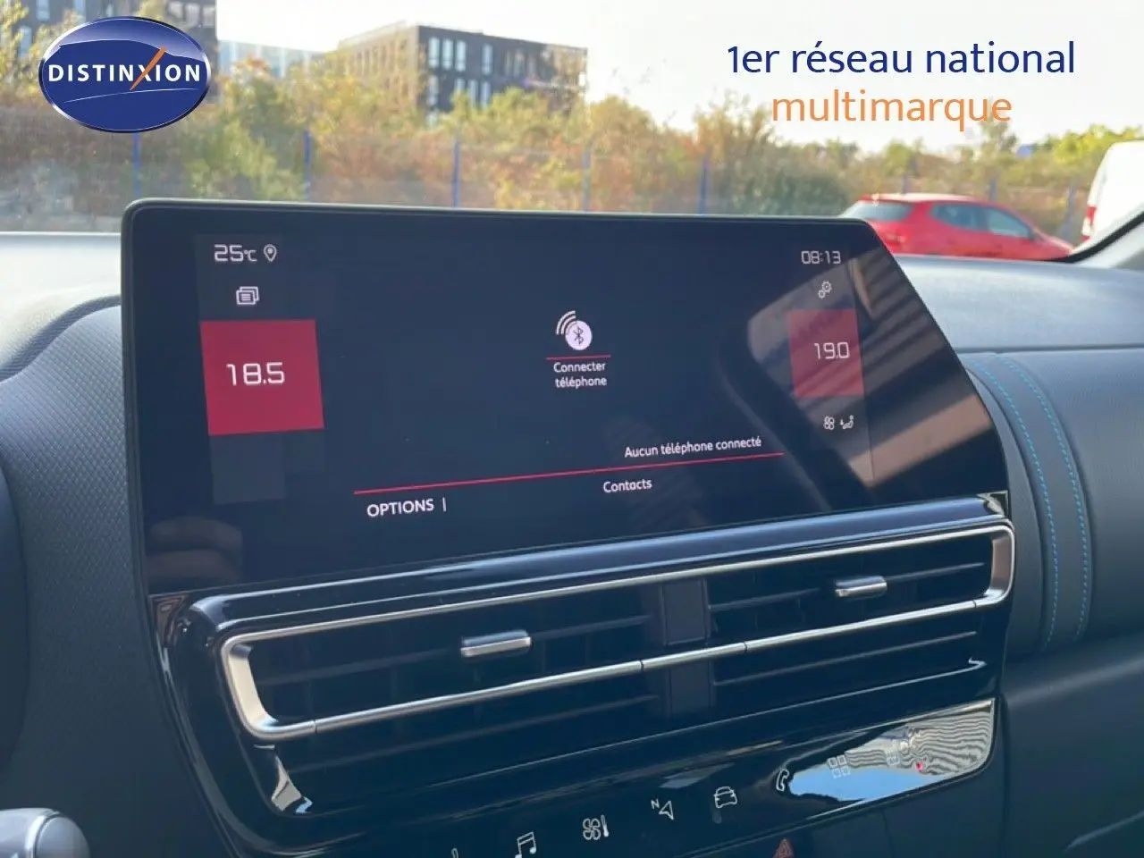 Vue rapprochée de l’écran tactile et de la console centrale du Citroën C5 Aircross 2025, intérieur gris avec surpiqûres bleues.