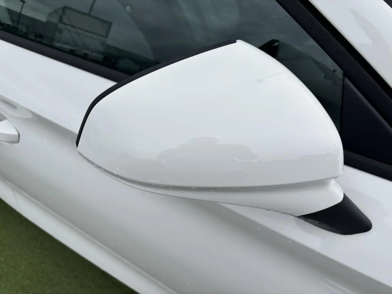 Rétroviseur côté gauche blanc brillant de la SEAT LEON IV 1.5 TSI 130CH STYLE PACK 2024 vue en gros plan.