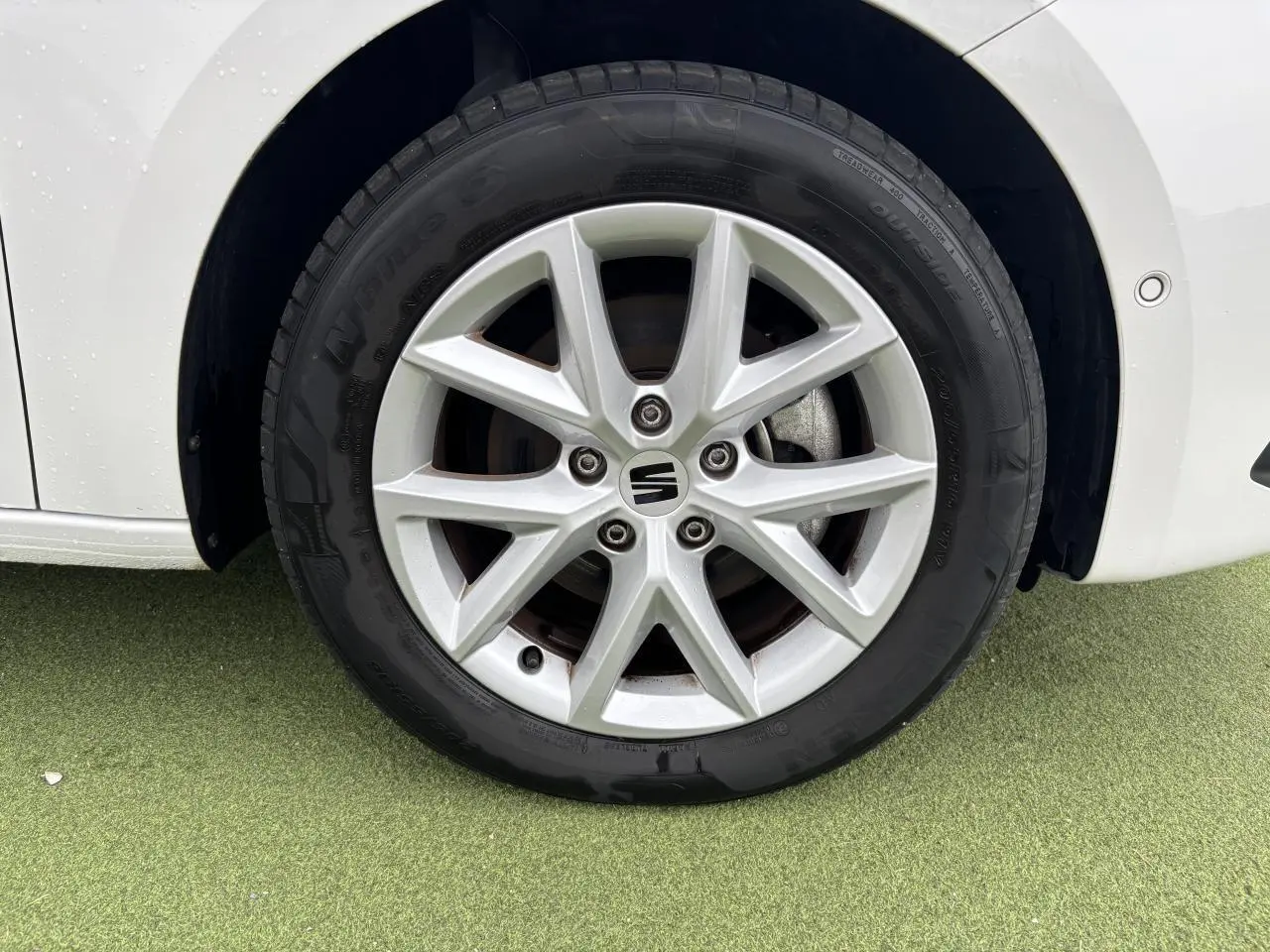 Gros plan sur la jante alliage 16 pouces Sunrise de la roue avant droite d'une SEAT LEON blanche 2024.