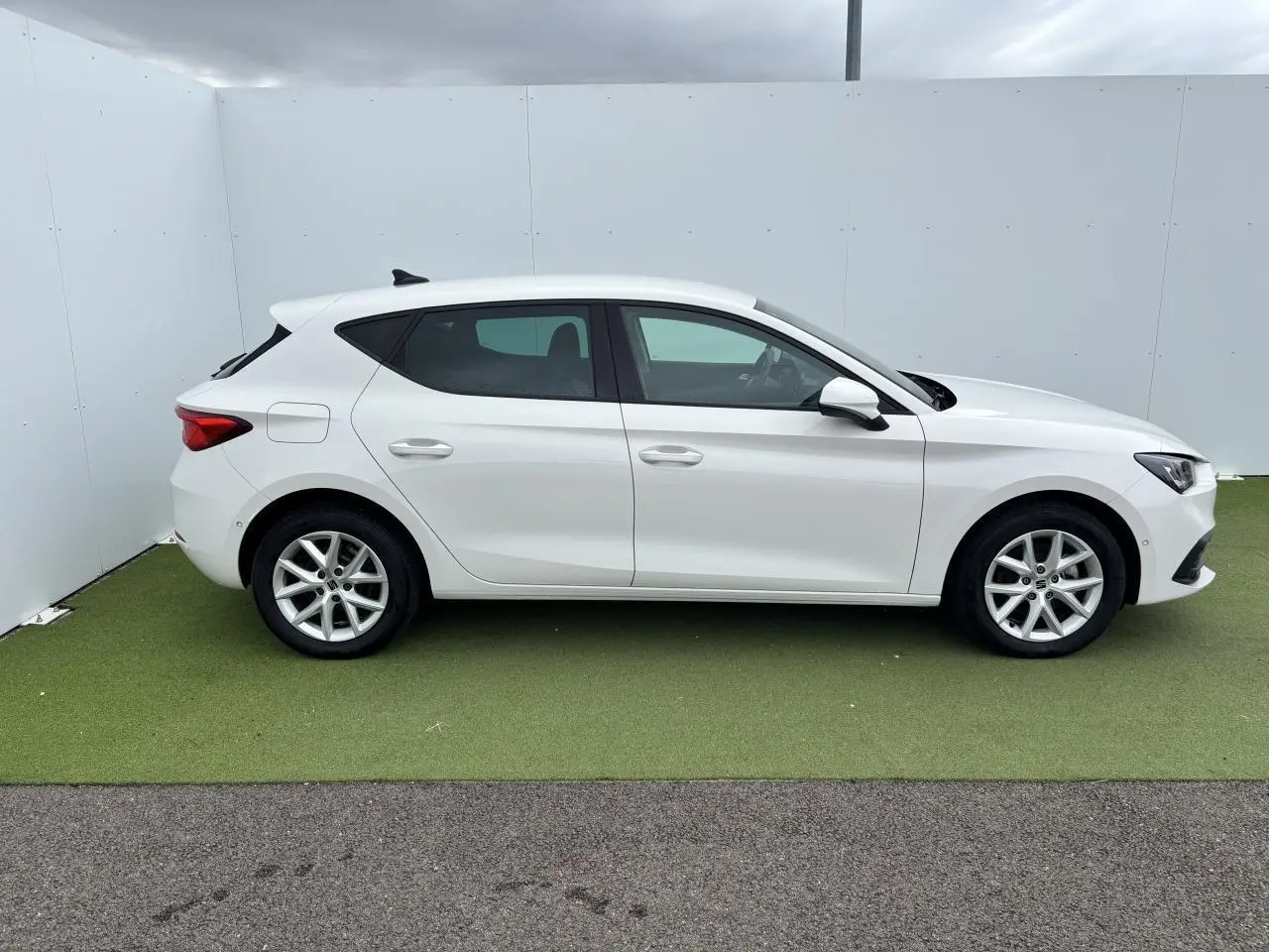 Profil côté gauche d'une SEAT LEON IV blanche 2024 avec jantes alliage 16 pouces sur fond neutre.