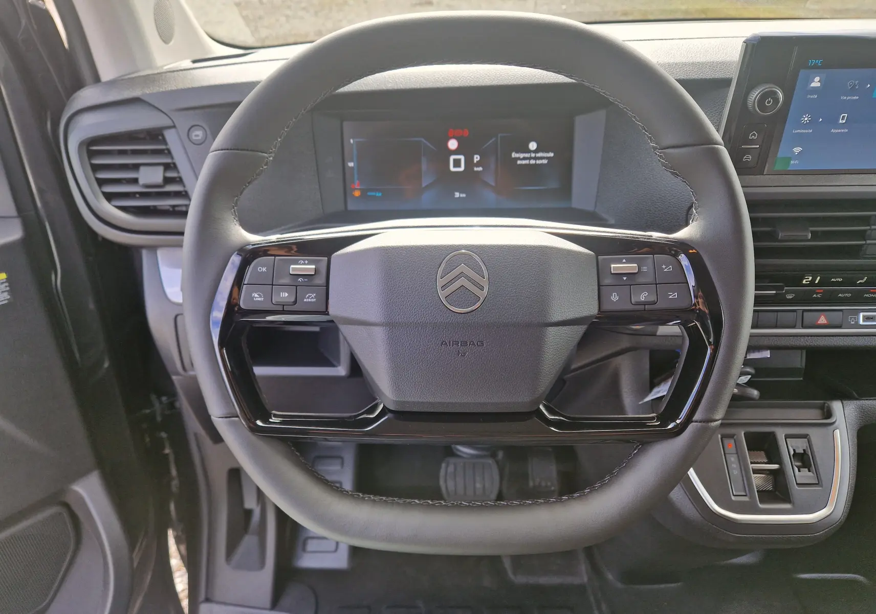 Vue rapprochée du volant cuir noir du Citroën Jumpy XL gris titane avec tableau de bord digital et commandes intégrées.