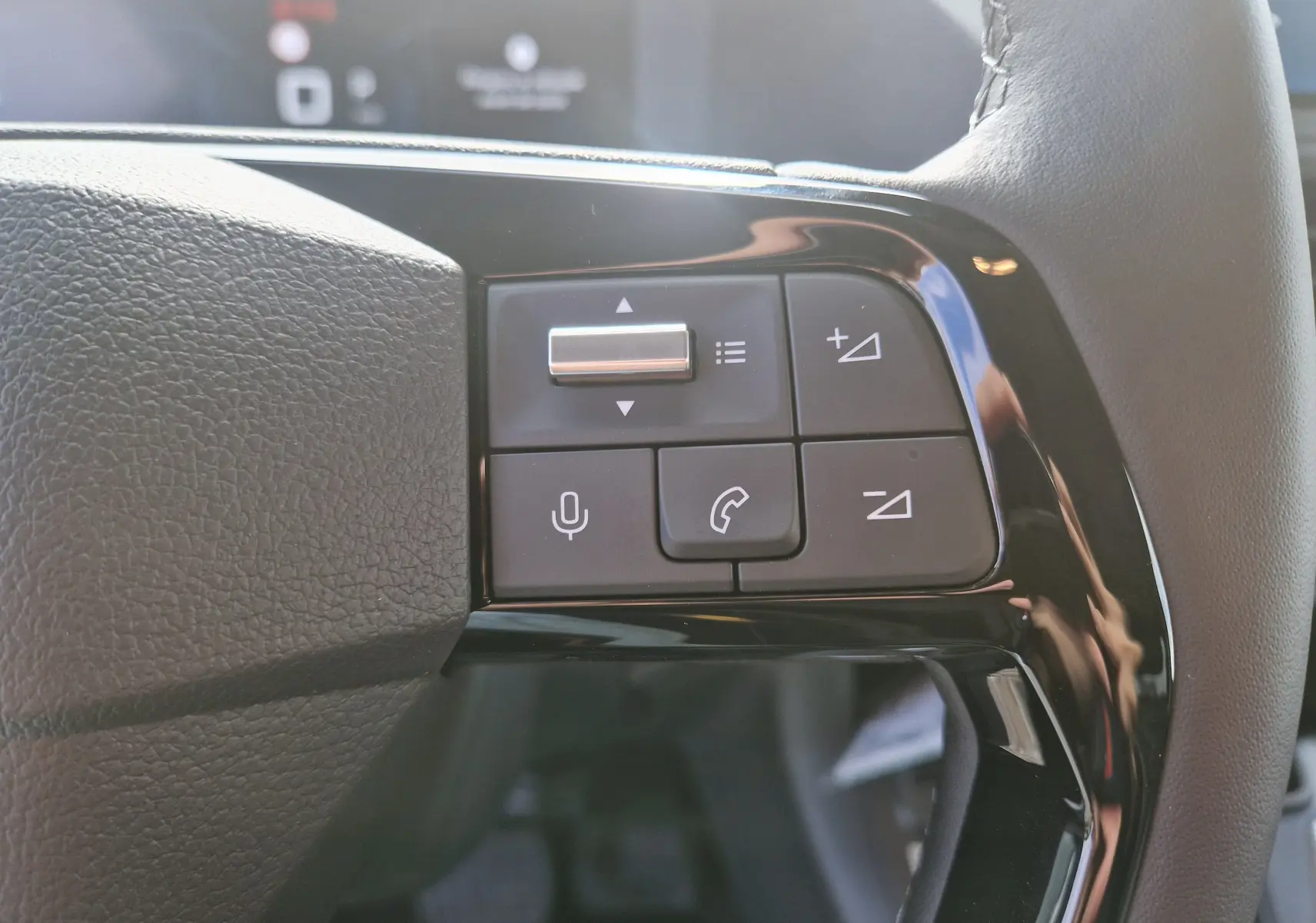 Gros plan sur les commandes du volant à droite du Citroën Jumpy Cabine Approfondie gris titane, boutons de volume et téléphone.