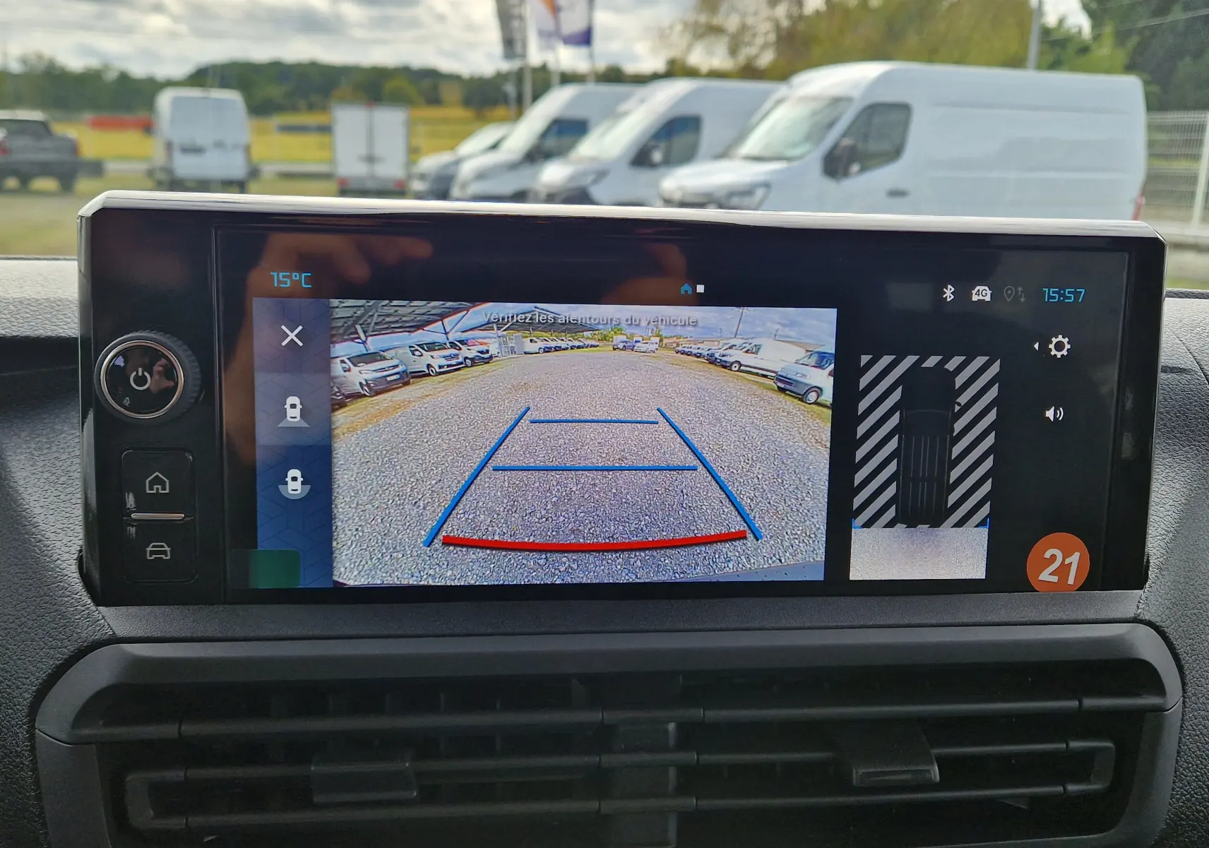 Écran de caméra de recul affichant une vue arrière avec lignes de guidage sur un Citroën Jumpy gris titane.