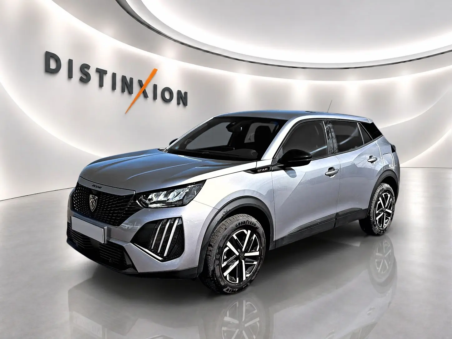 Peugeot 2008 gris en 3/4 avant droit, avec jantes noires et toit noir dans un showroom lumineux.