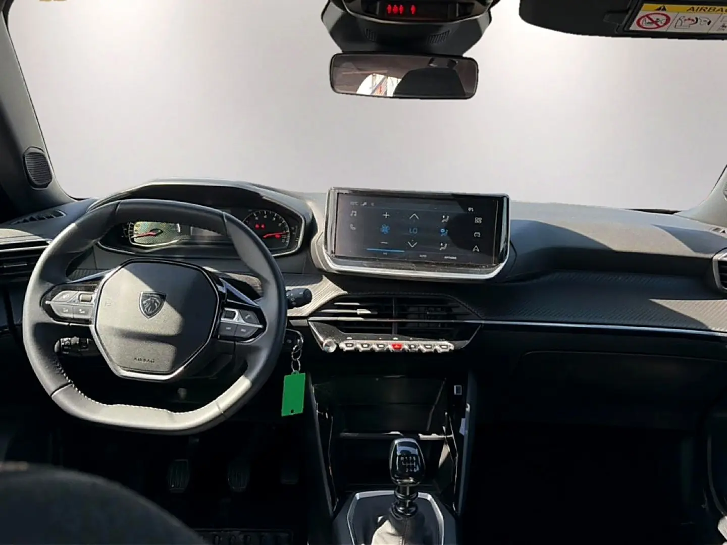 Vue intérieure avant du Peugeot 2008 gris 1.2 100 style, avec volant multifonction et écran tactile central.