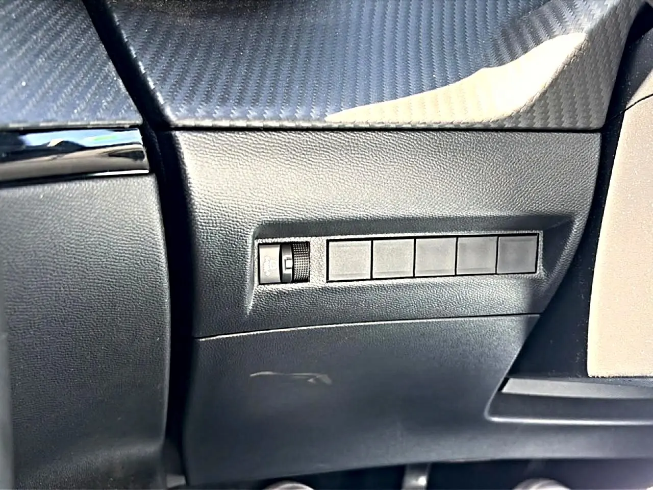 Détail intérieur côté conducteur du tableau de bord gris avec commande de réglage de l’éclairage sur Peugeot 2008 2025.