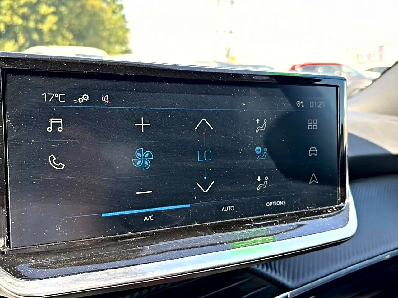 Écran tactile de la climatisation du Peugeot 2008 gris, vue rapprochée de l'intérieur côté conducteur.