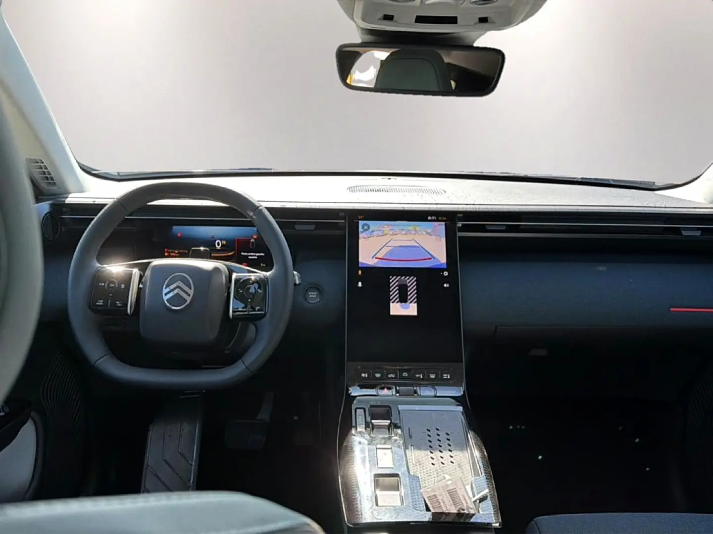 Vue intérieure avant du Citroën C5 Aircross hybride 2026, volant multifonction et écran tactile central allumé.