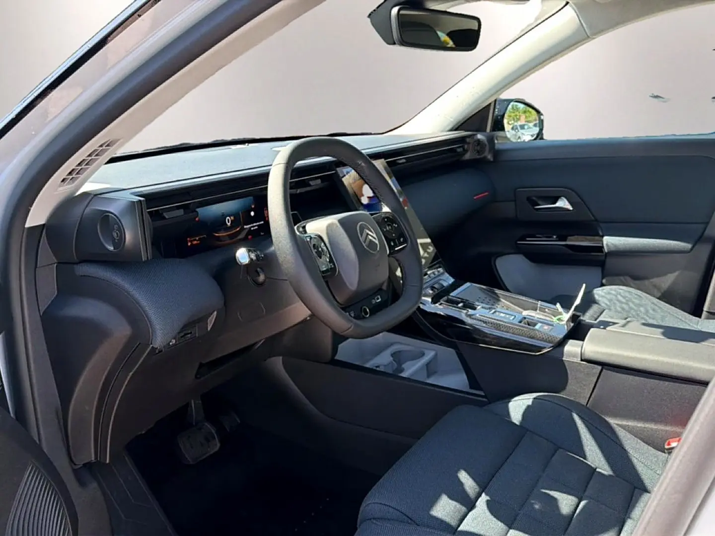 Vue intérieure côté conducteur du Citroën C5 Aircross 2026, tableau de bord numérique et volant multifonction noir.