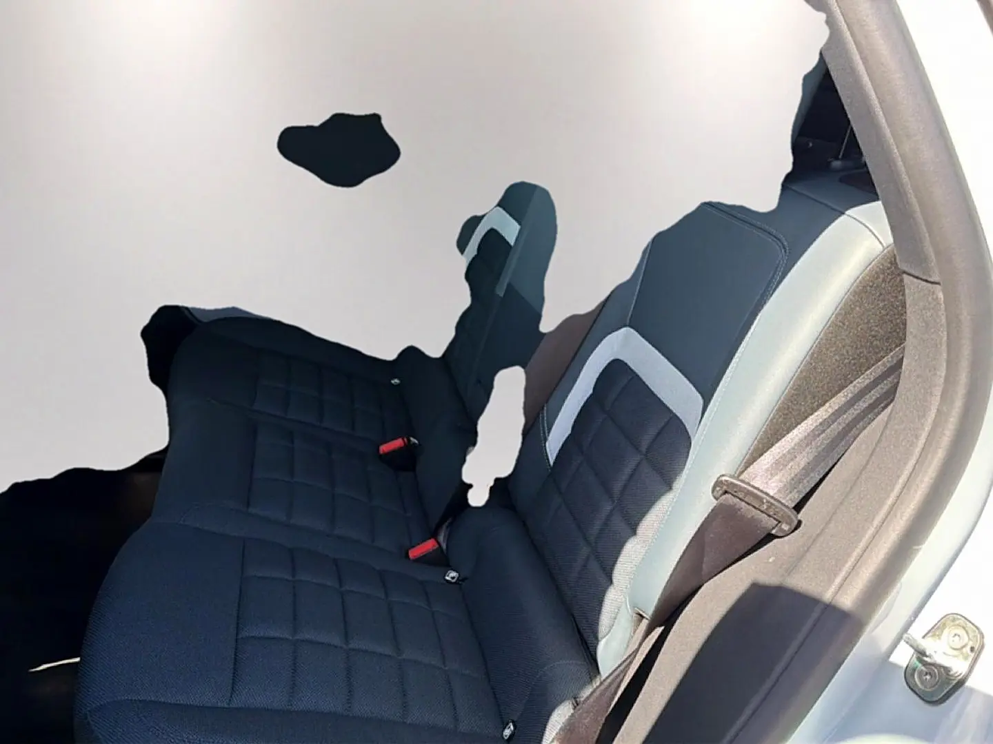 Vue intérieure côté droit de la banquette arrière noire avec surpiqûres et ceinture de sécurité dans un Citroën C5 Aircross blanc.