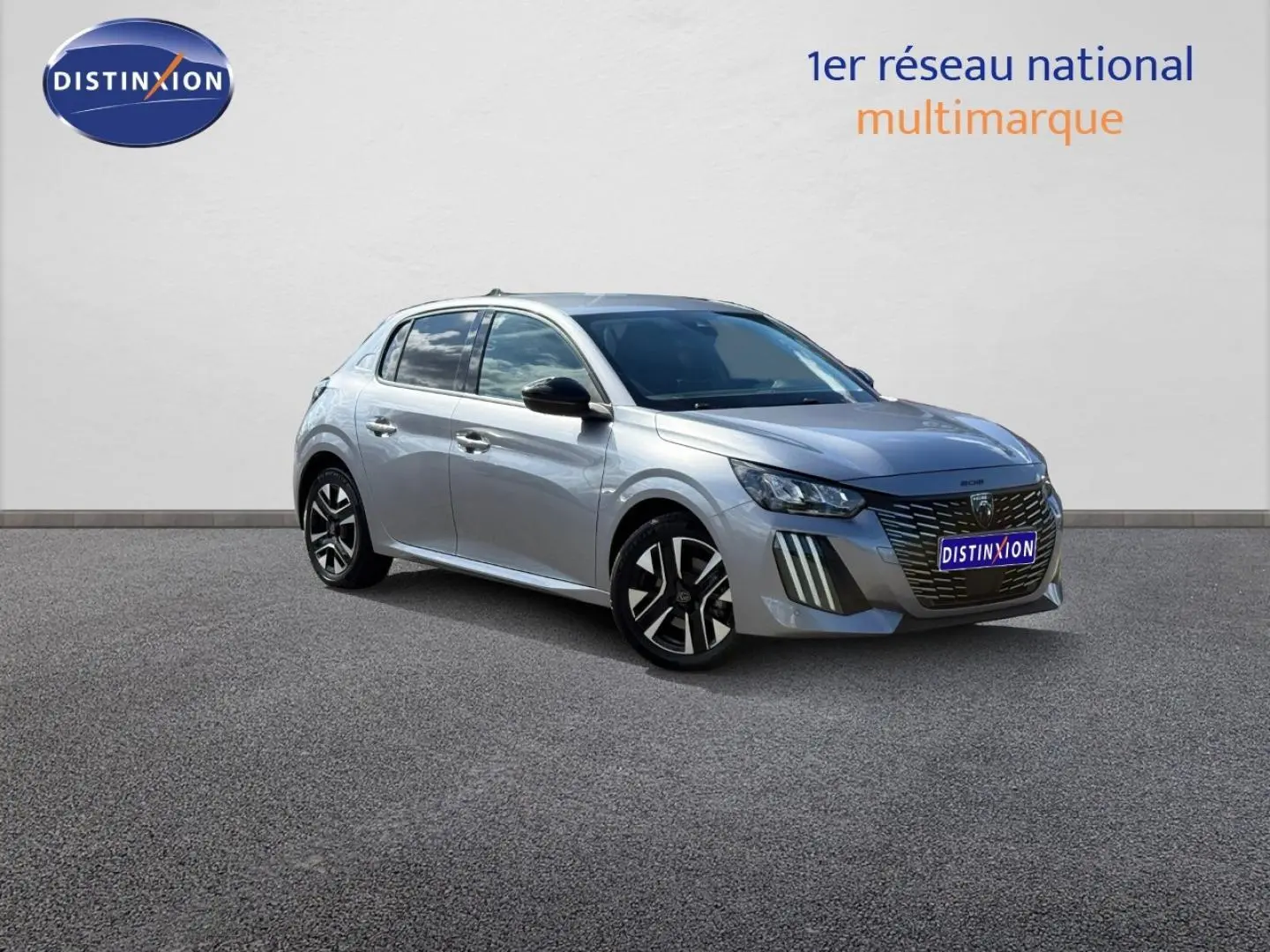 Peugeot 208 gris Artense vue 3/4 avant droit, avec jantes alu et calandre noire distinctive.