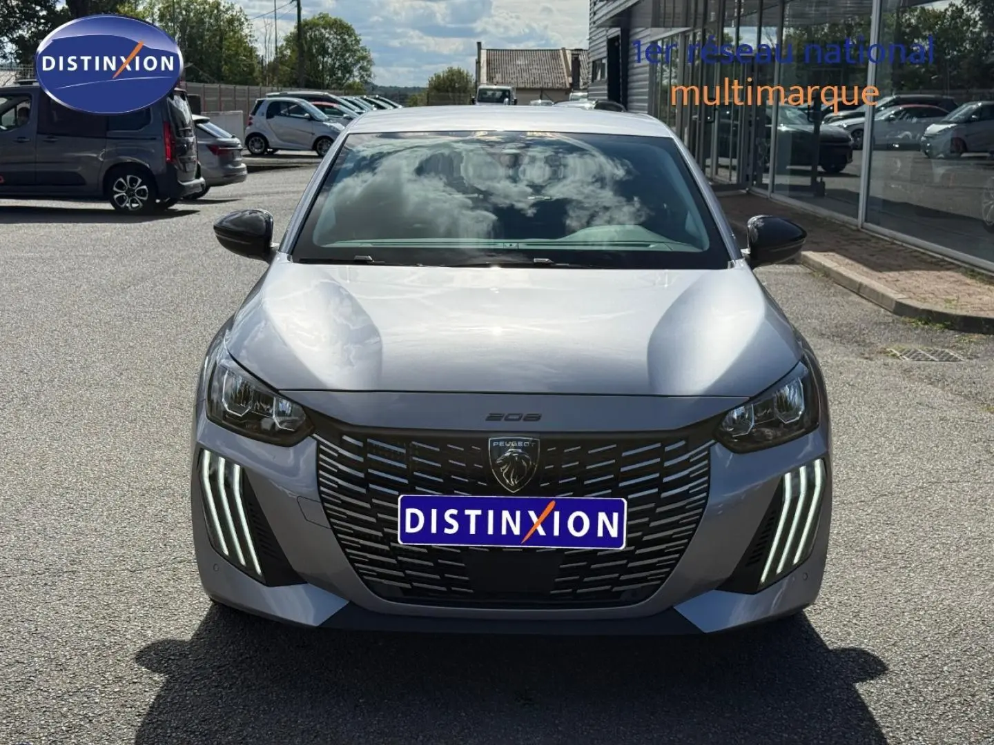 Vue avant frontale d'une Peugeot 208 gris Artense avec feux LED verticaux et calandre noire distinctive.