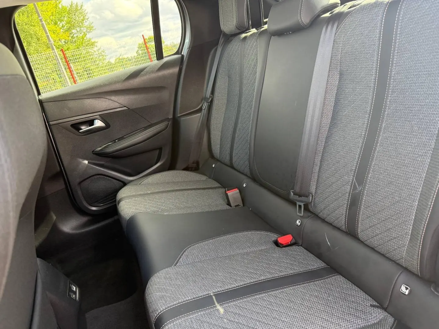 Vue intérieure côté droit sur la banquette arrière grise tissu et cuir de la Peugeot 208 1.2 100ch Allure 2025.