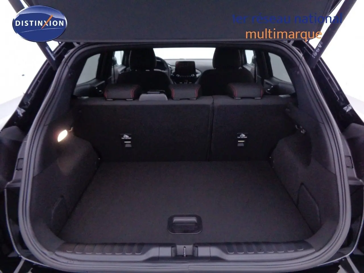 Coffre ouvert d'un Ford Puma noir agate 2022, vue arrière montrant l'espace de chargement et les sièges arrière.