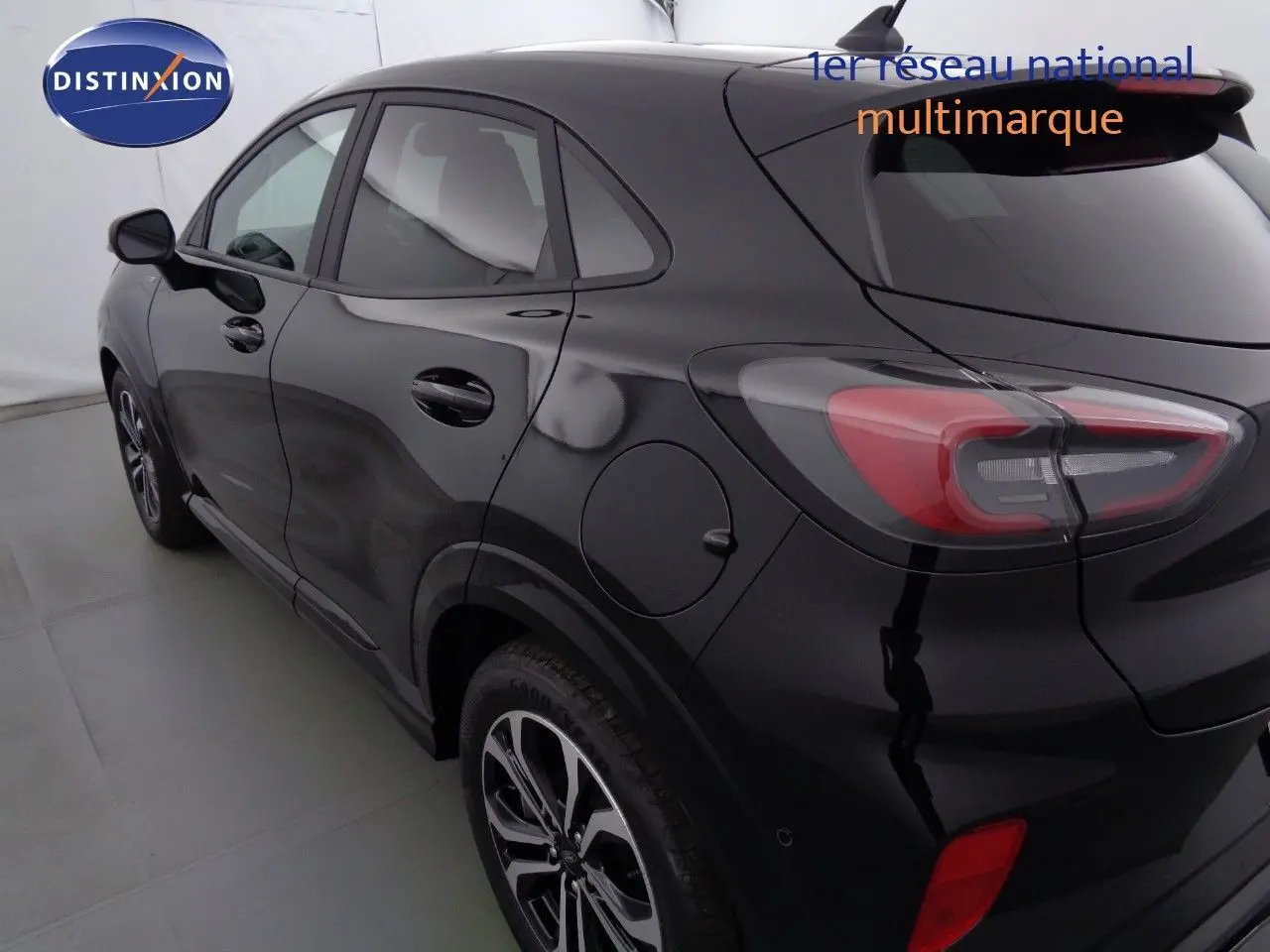 Vue 3/4 arrière côté gauche d'un Ford Puma noir Agate avec feux arrière LED et jantes alliage distinctives.