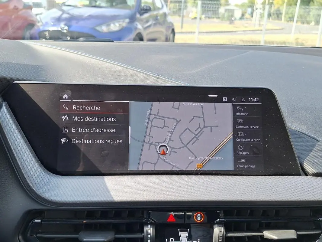 Écran tactile GPS de la BMW Série 1 120i M Sport 2021, vue intérieure du tableau de bord en lumière naturelle.