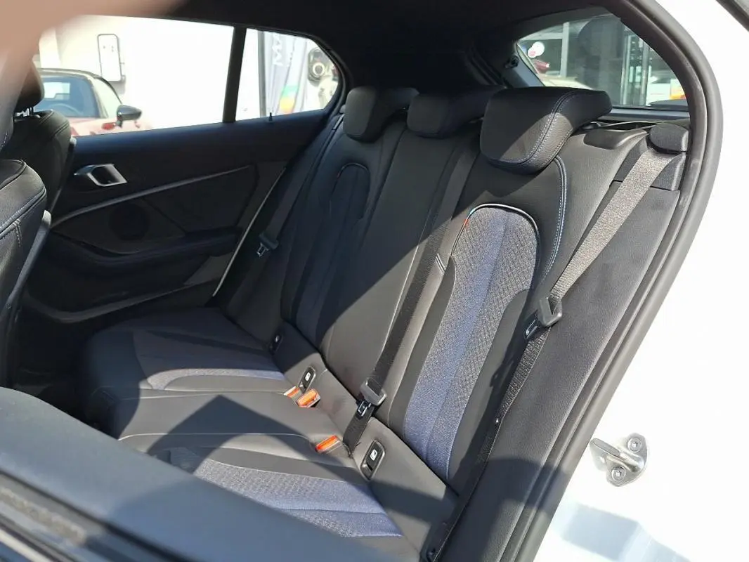 Vue intérieure sur les sièges arrière en tissu noir et bleu de la BMW Série 1 120i M Sport blanche de 2021.