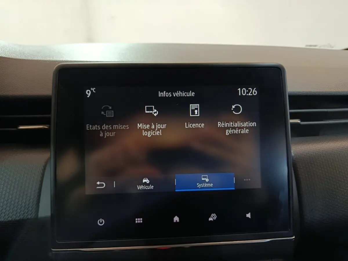 Écran tactile central de la Renault Clio gris clair 2023 affichant les options de mise à jour logiciel et système.