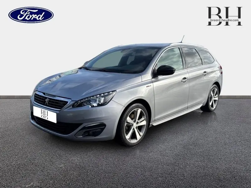 Peugeot 308 SW gris Artense vue 3/4 avant droit, break compact avec jantes alliage et rétroviseurs noirs.