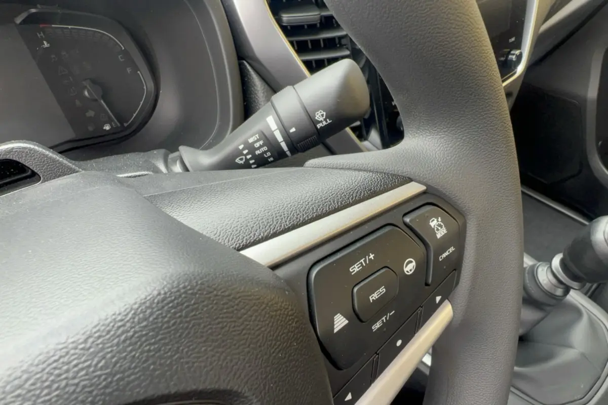 Gros plan sur le volant multifonctions noir de l'Isuzu D-MAX 2026, avec commandes de régulateur de vitesse visibles.
