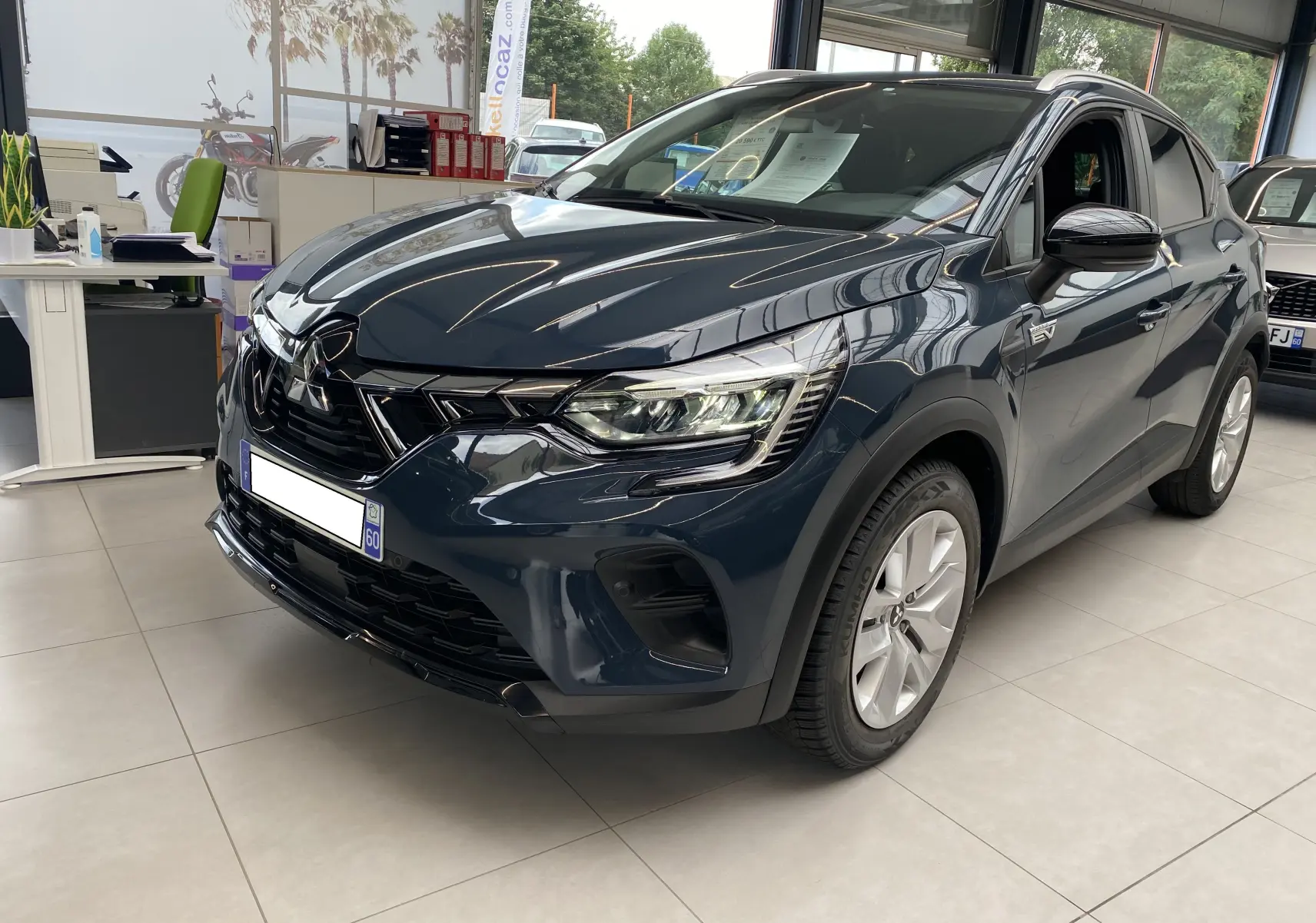 Mitsubishi ASX 2023 Steel Gray métallisé en 3/4 avant droit, SUV hybride essence avec calandre noire et jantes argentées.