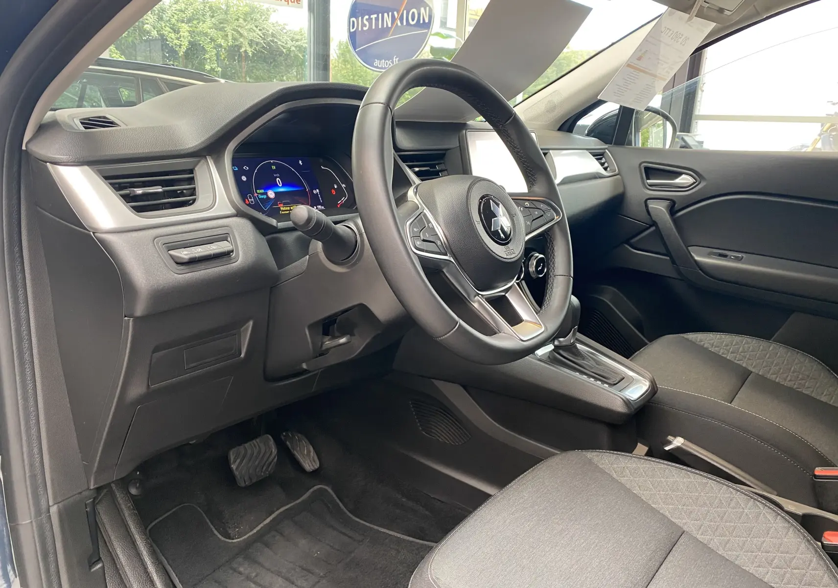 Intérieur du Mitsubishi ASX 2023 vu côté conducteur, volant multifonction et tableau de bord digital visibles.