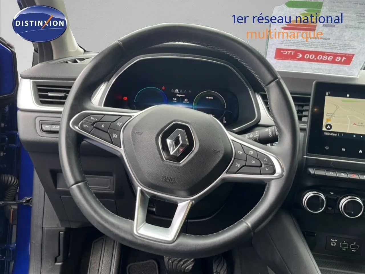 Vue intérieure centrée sur le volant noir de la Renault Captur bleu iron metal, avec tableau de bord numérique et écran tactile.