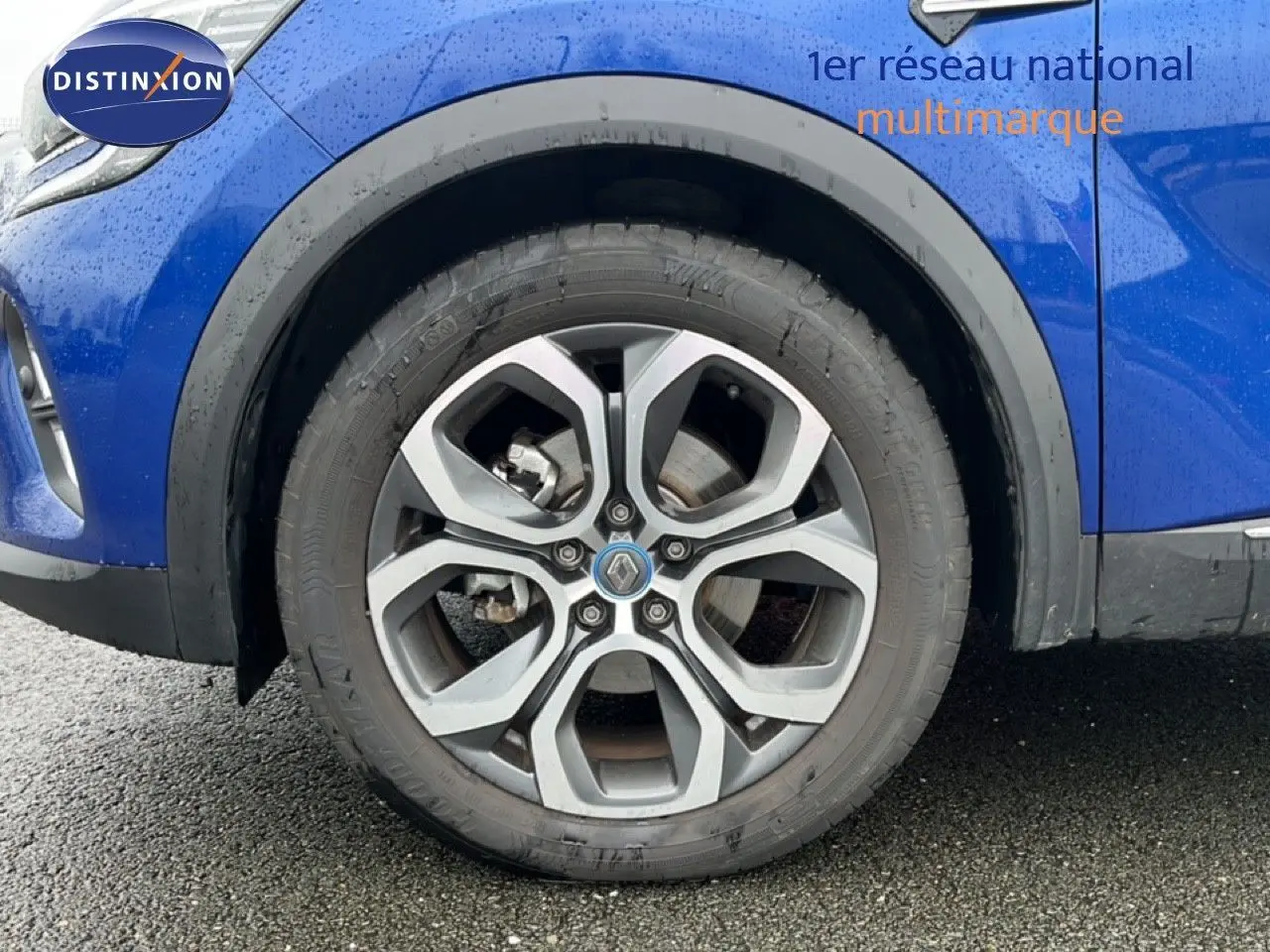 Vue latérale gauche du Renault Captur bleu iron metal avec toit noir, mettant en valeur l'aile avant et la roue.