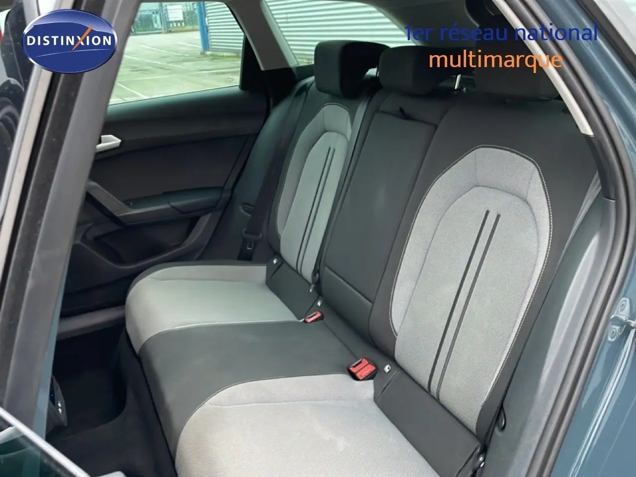 Vue intérieure sur la banquette arrière bicolore gris clair et noir du SEAT LEON ST bleu Fjord, porte arrière ouverte.