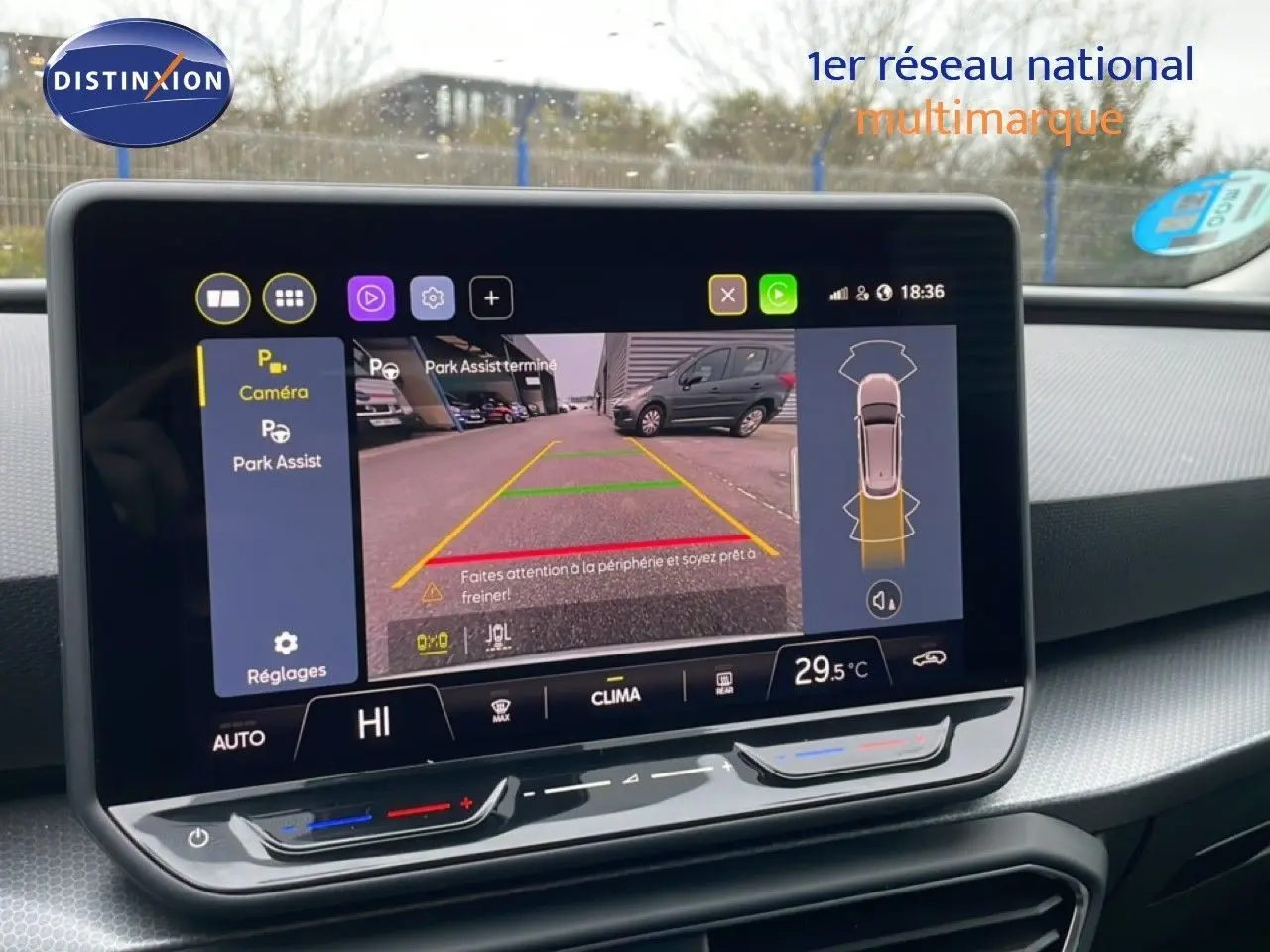 Écran central affichant la caméra de recul et l'assistance au stationnement dans un SEAT LEON ST bleu Fjord.