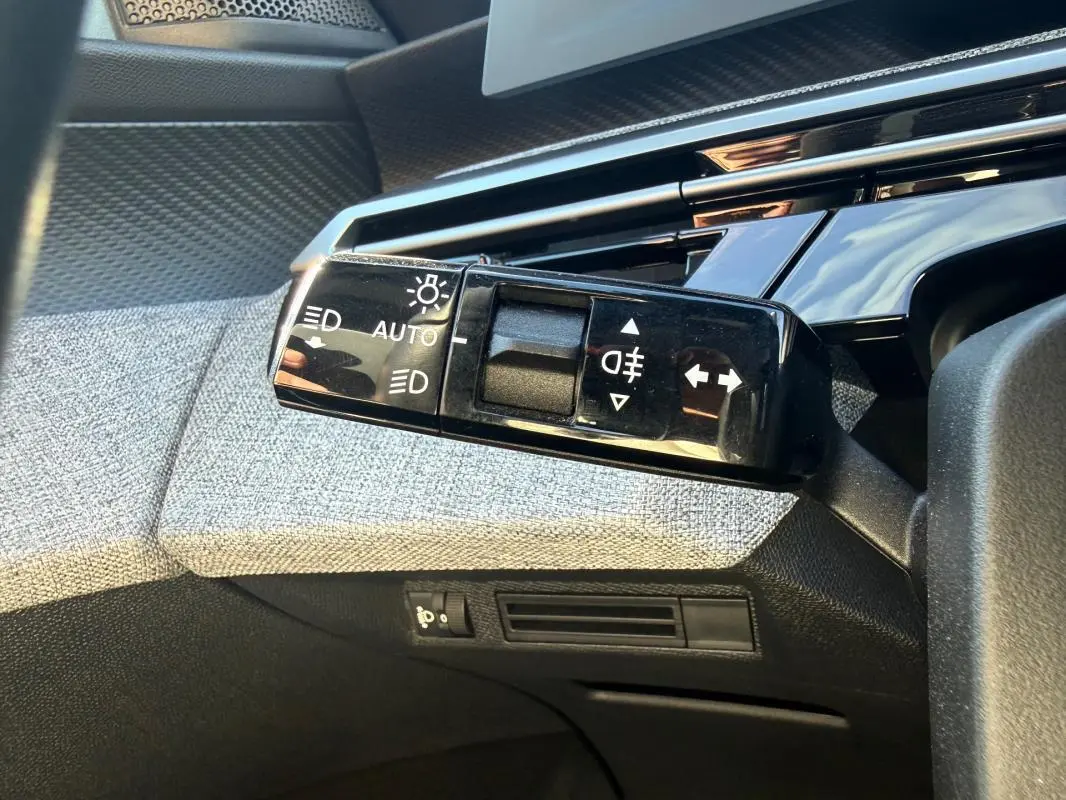 Gros plan sur la commande des feux et clignotants dans l’habitacle gris du Peugeot 3008 Hybrid 145 e-DCS6 Allure 2025.