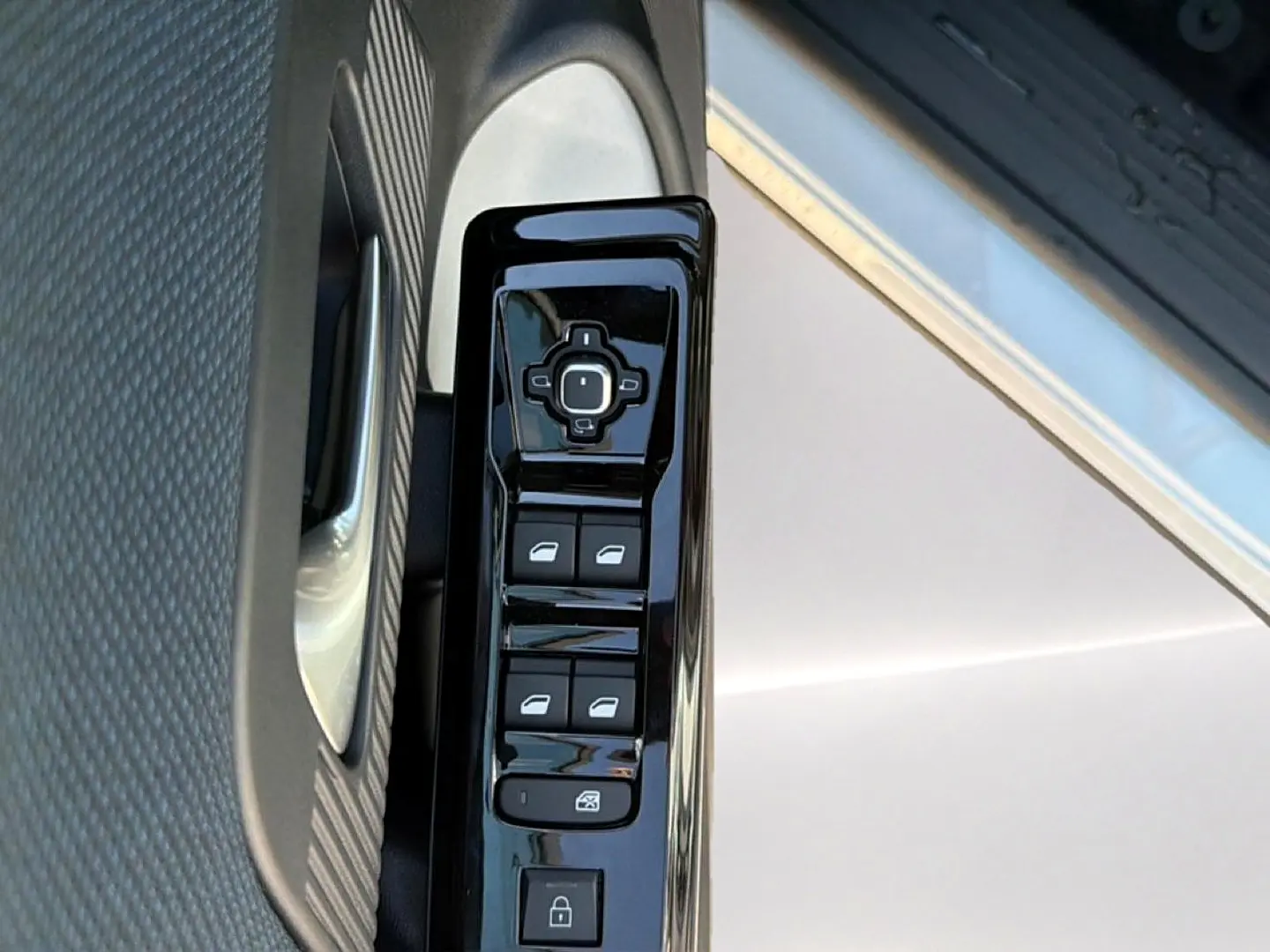 Gros plan sur les commandes de lève-vitres et rétroviseurs côté conducteur d’un Citroën C5 Aircross blanc et noir.