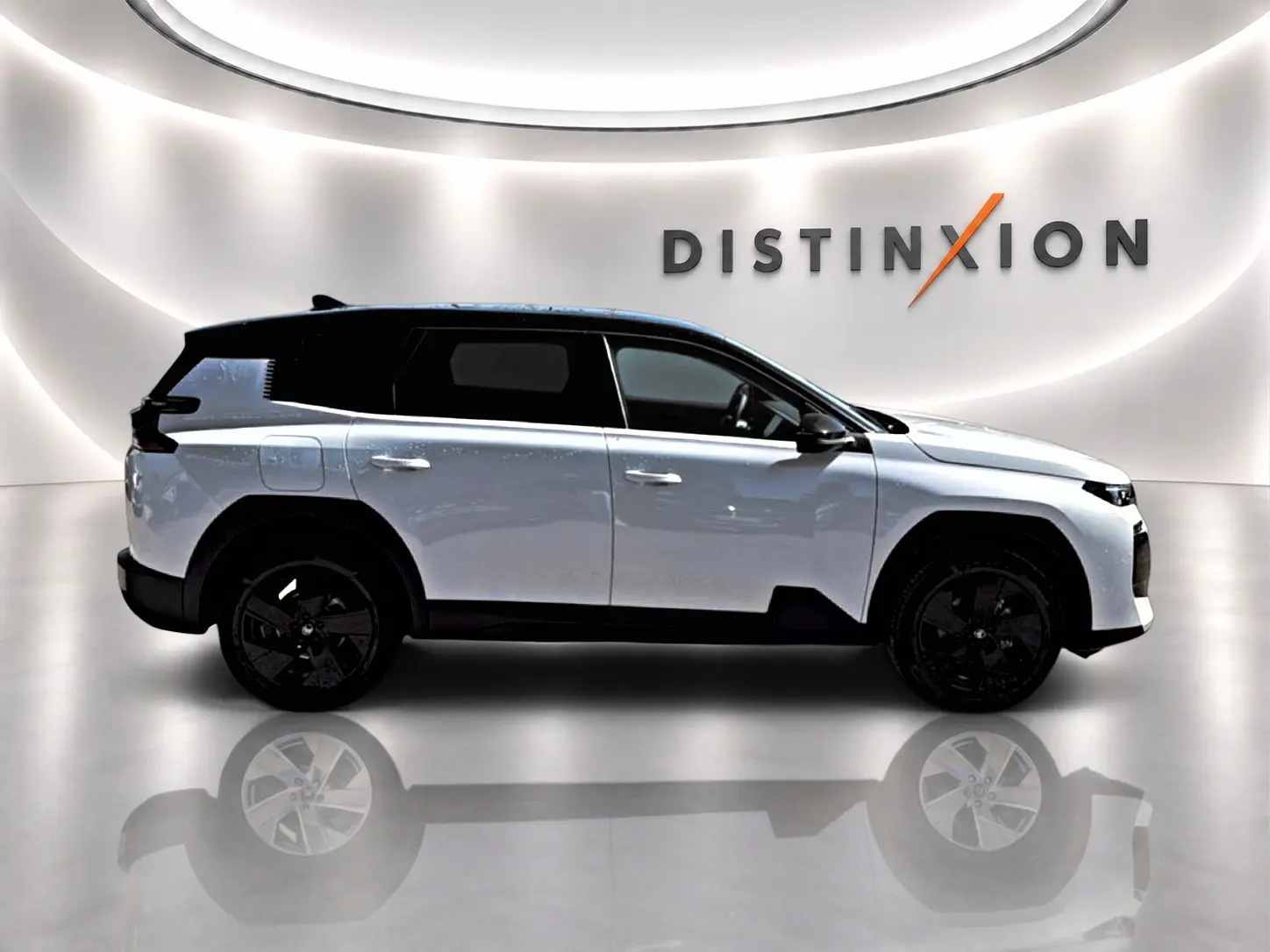 Profil droit du Citroën C5 Aircross hybride 2026 blanc avec toit noir et jantes alliage noires, sur fond lumineux intérieur.