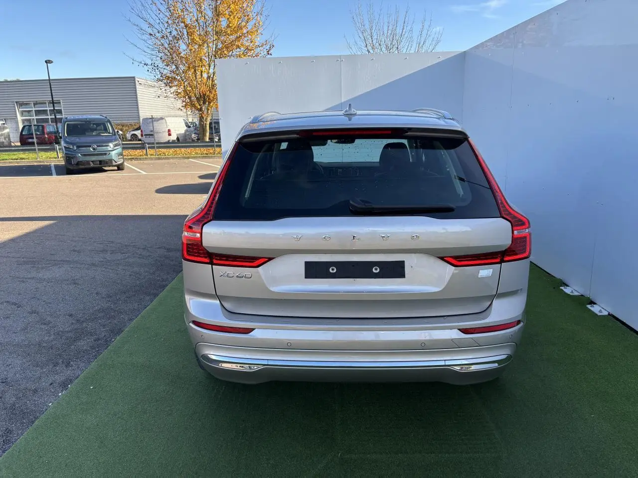 Vue arrière d'un Volvo XC60 argent crépuscule métal avec feux arrière LED en forme de L et hayon électrique.