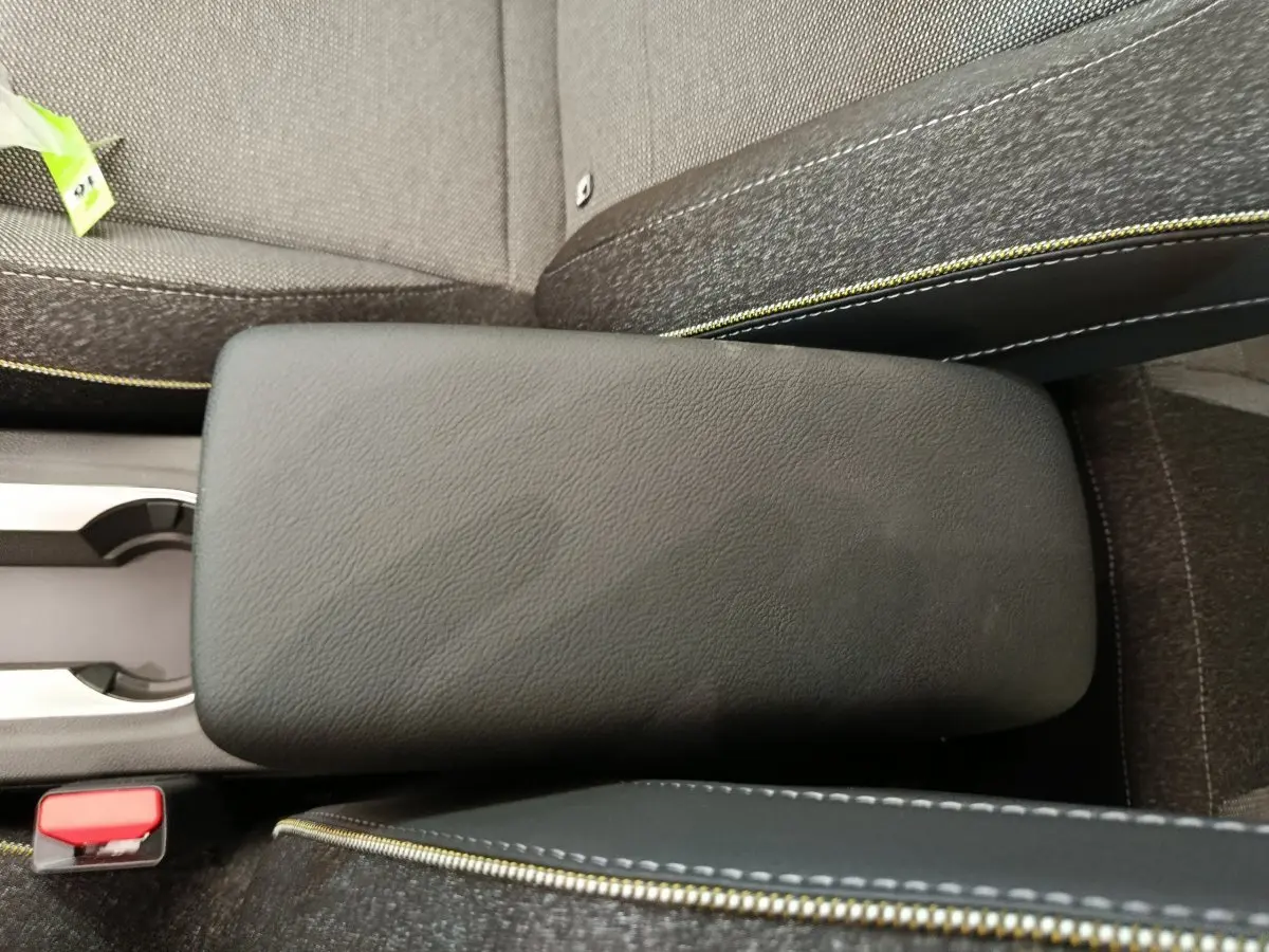 Accoudoir central noir avec surpiqûres jaunes entre les sièges avant du Renault Captur Techno Eco-G 2025.