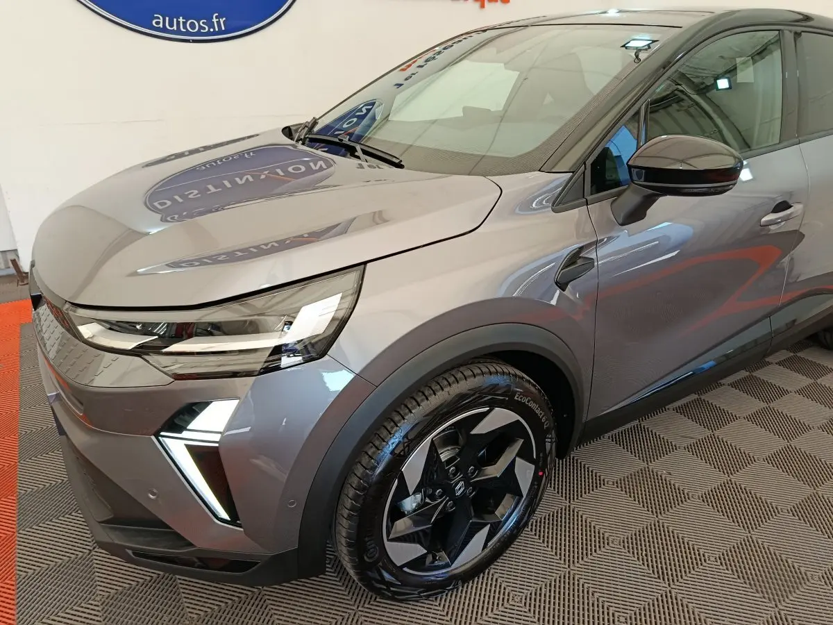 Vue 3/4 avant droit d'un Renault Captur gris foncé avec phares LED et jantes noires au design moderne.