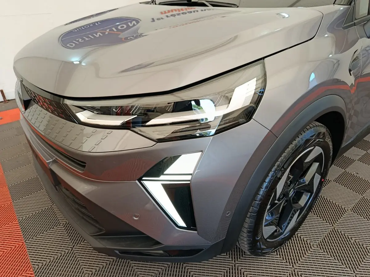 Gros plan sur l'avant droit du Renault Captur gris foncé 2025 avec phares LED et jante noire au design moderne.