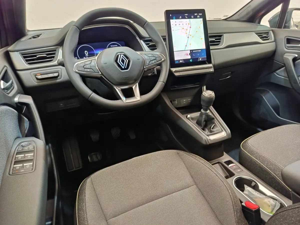 Intérieur du Renault Captur 2025 vu de face, volant multifonctions, écran tactile vertical et levier de vitesse manuel.