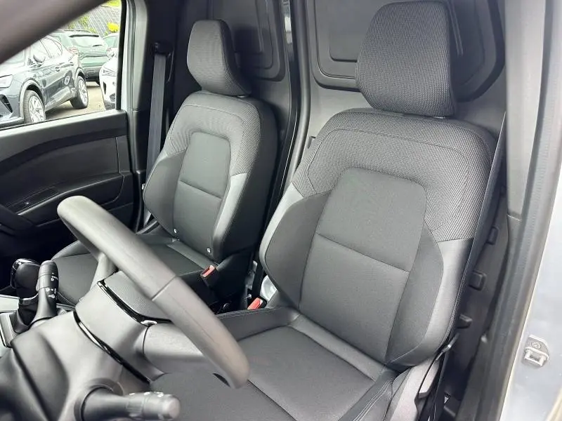 Intérieur du Nissan Townstar gris 2024, vue sur les sièges avant en tissu noir et le volant côté gauche.