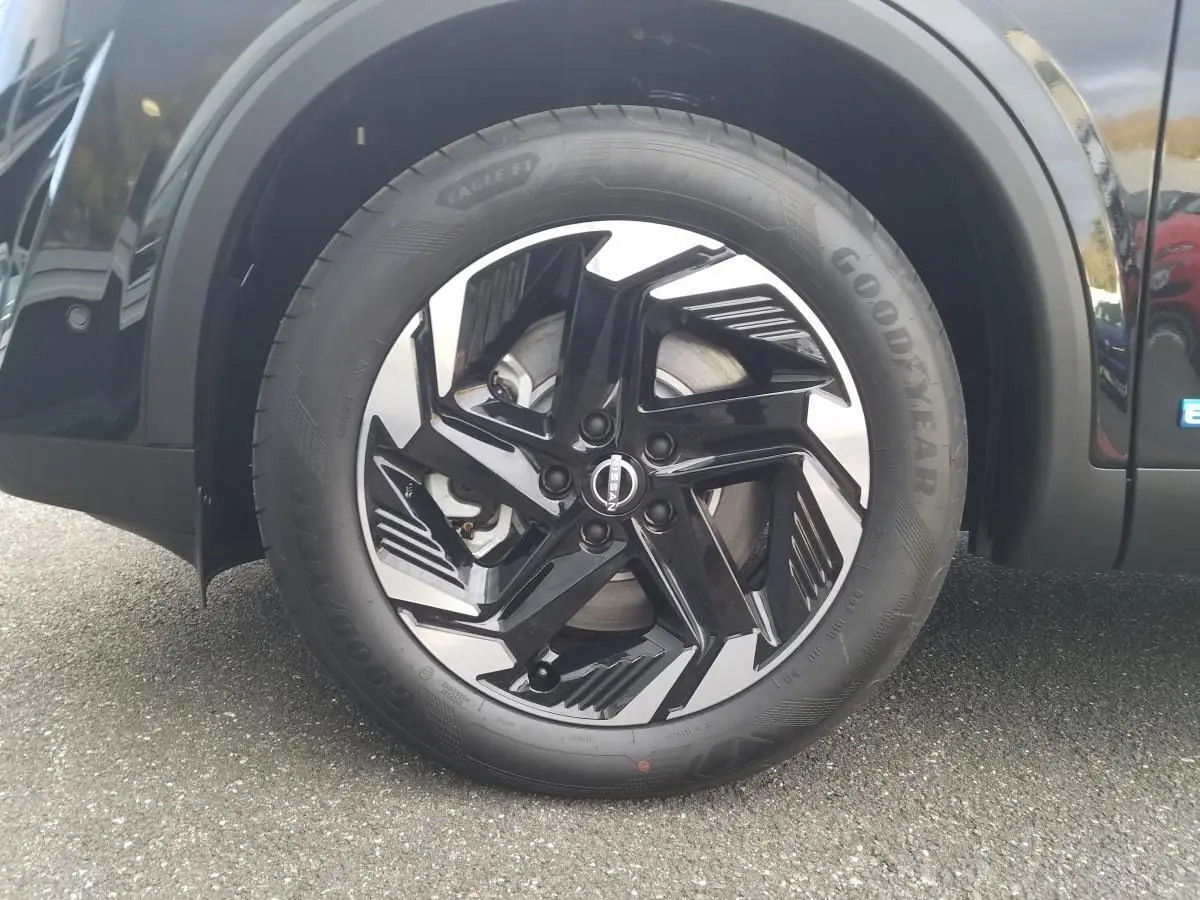 Gros plan sur la roue avant droite du Nissan Qashqai noire avec jante alliage 18 pouces au design moderne.