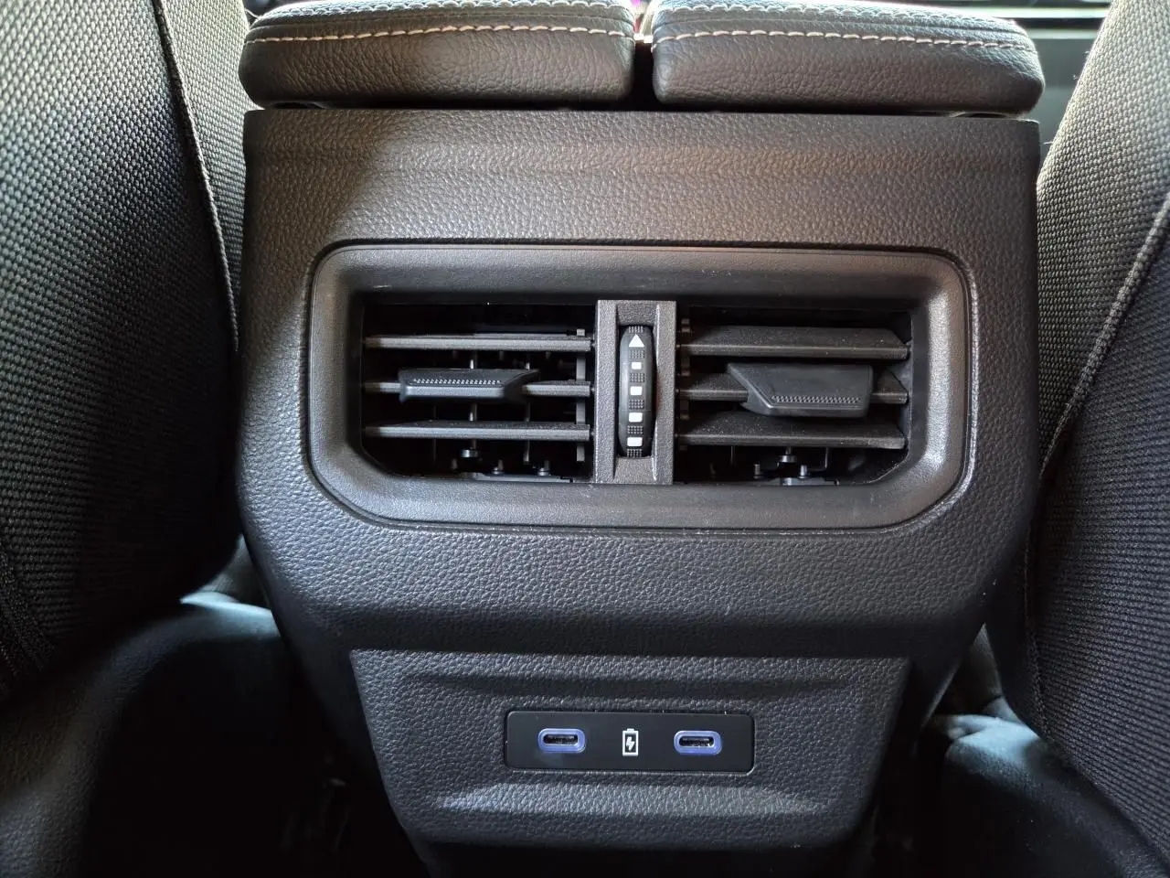 Gros plan sur la sortie d'air arrière noire et les deux ports USB-C du Renault Austral E-Tech blanc nacré.