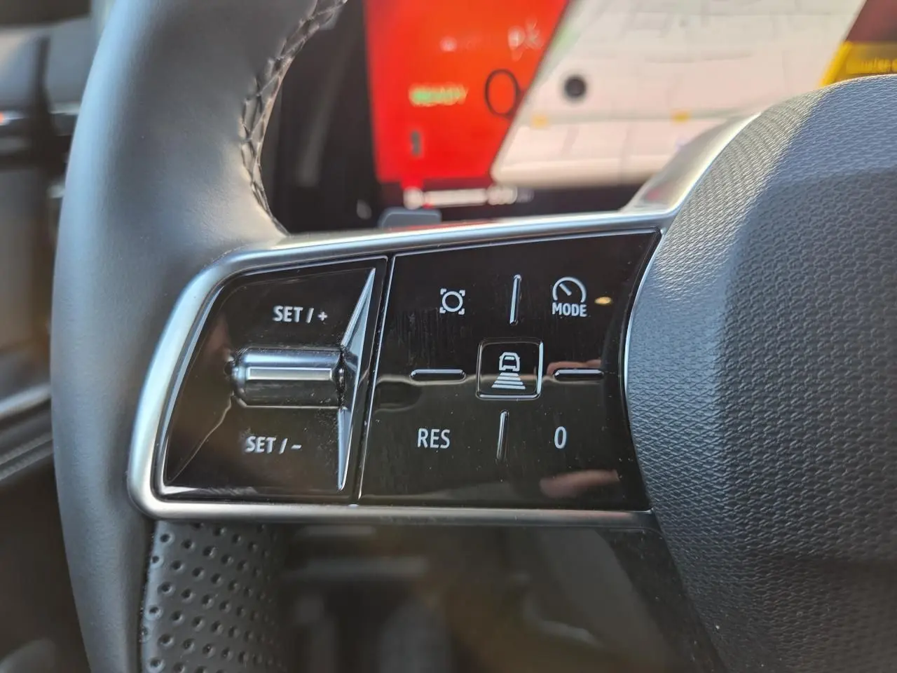 Gros plan sur les commandes du volant du Renault Austral 2025, finition E-Tech hybride, avec écran tactile en arrière-plan.