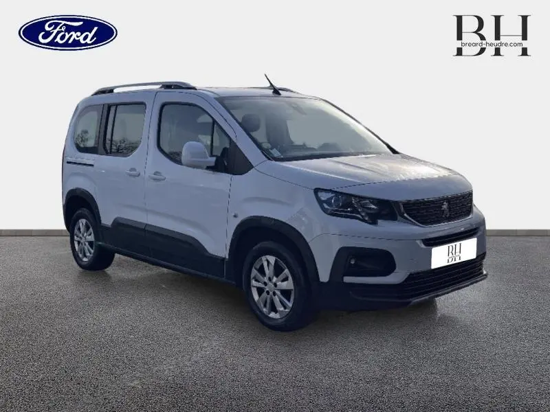 Peugeot Rifter blanc vue 3/4 avant droit avec barres de toit et jantes alliage 16 pouces.