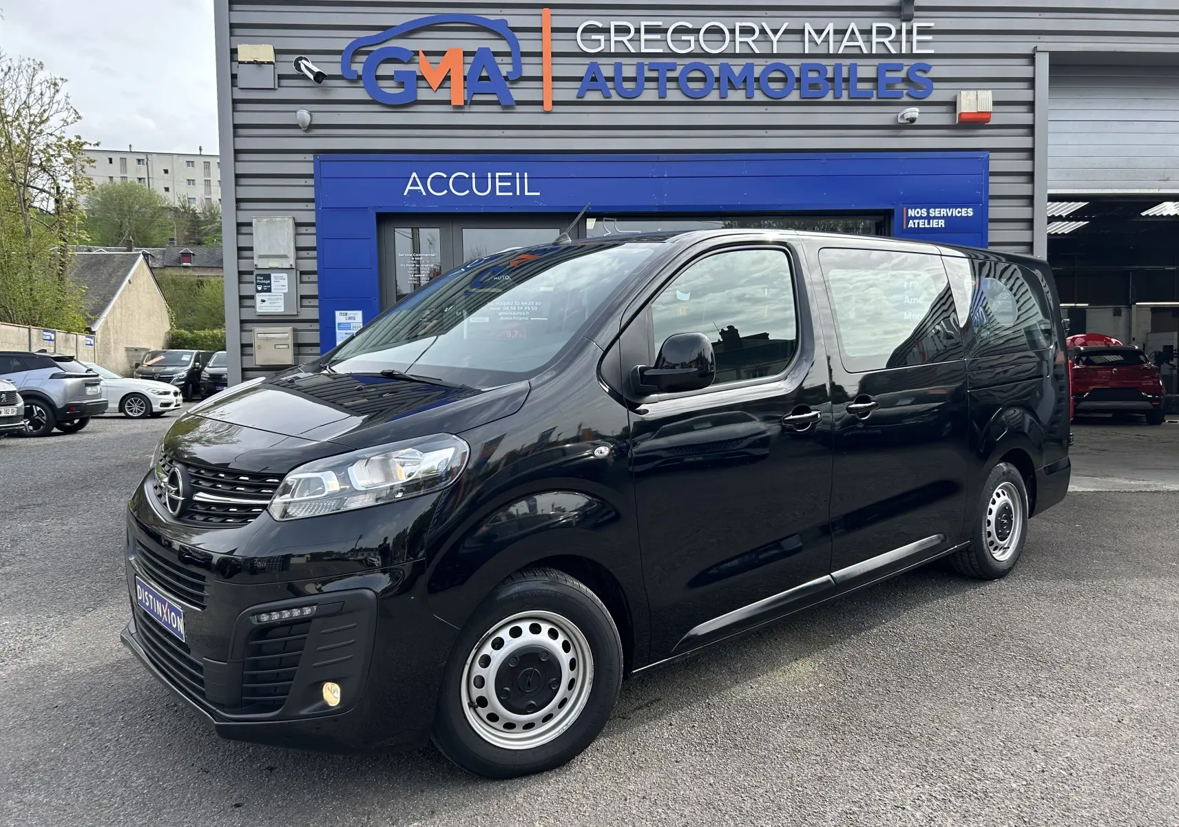 Opel Vivaro Combi noir en 3/4 avant droit, garé devant un garage Gregory Marie Automobiles.