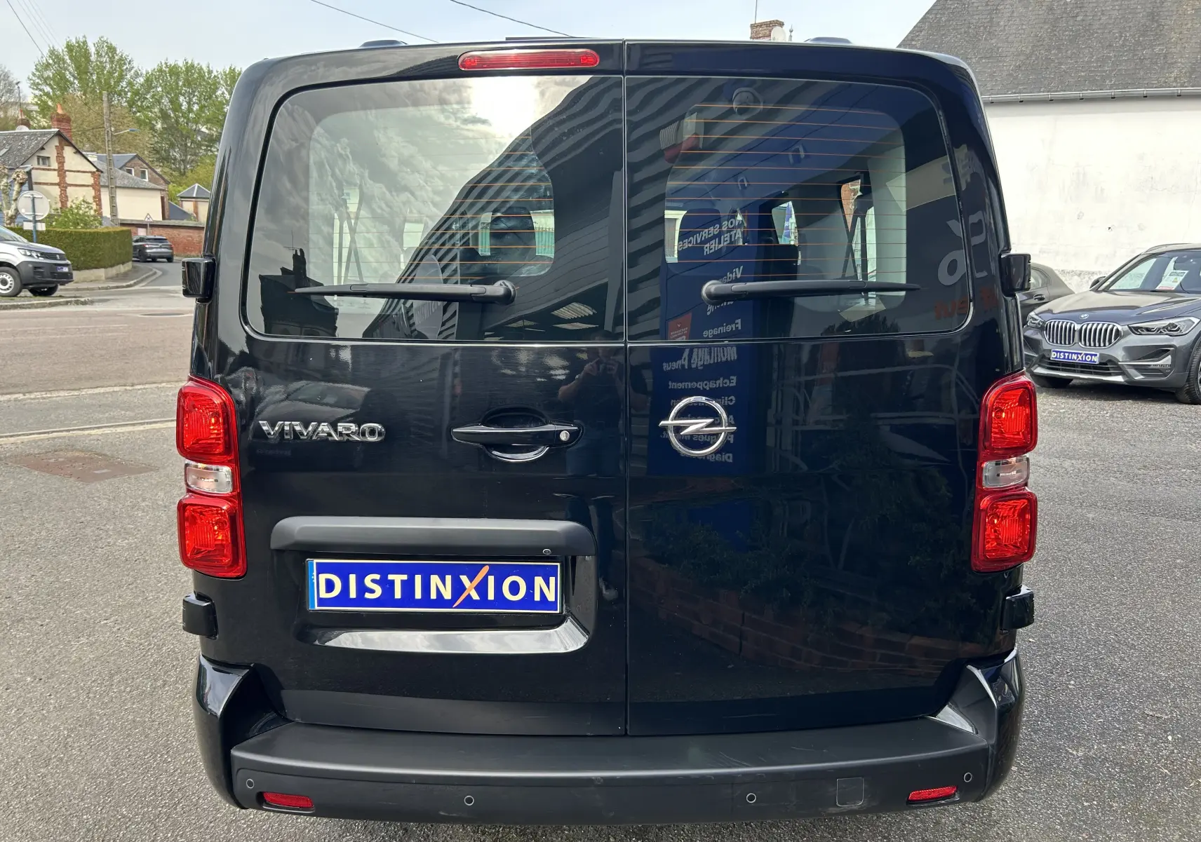 Vue arrière d'un Opel Vivaro Combi noir avec portes battantes et feux rouges bien visibles, immatriculé Distinxion.