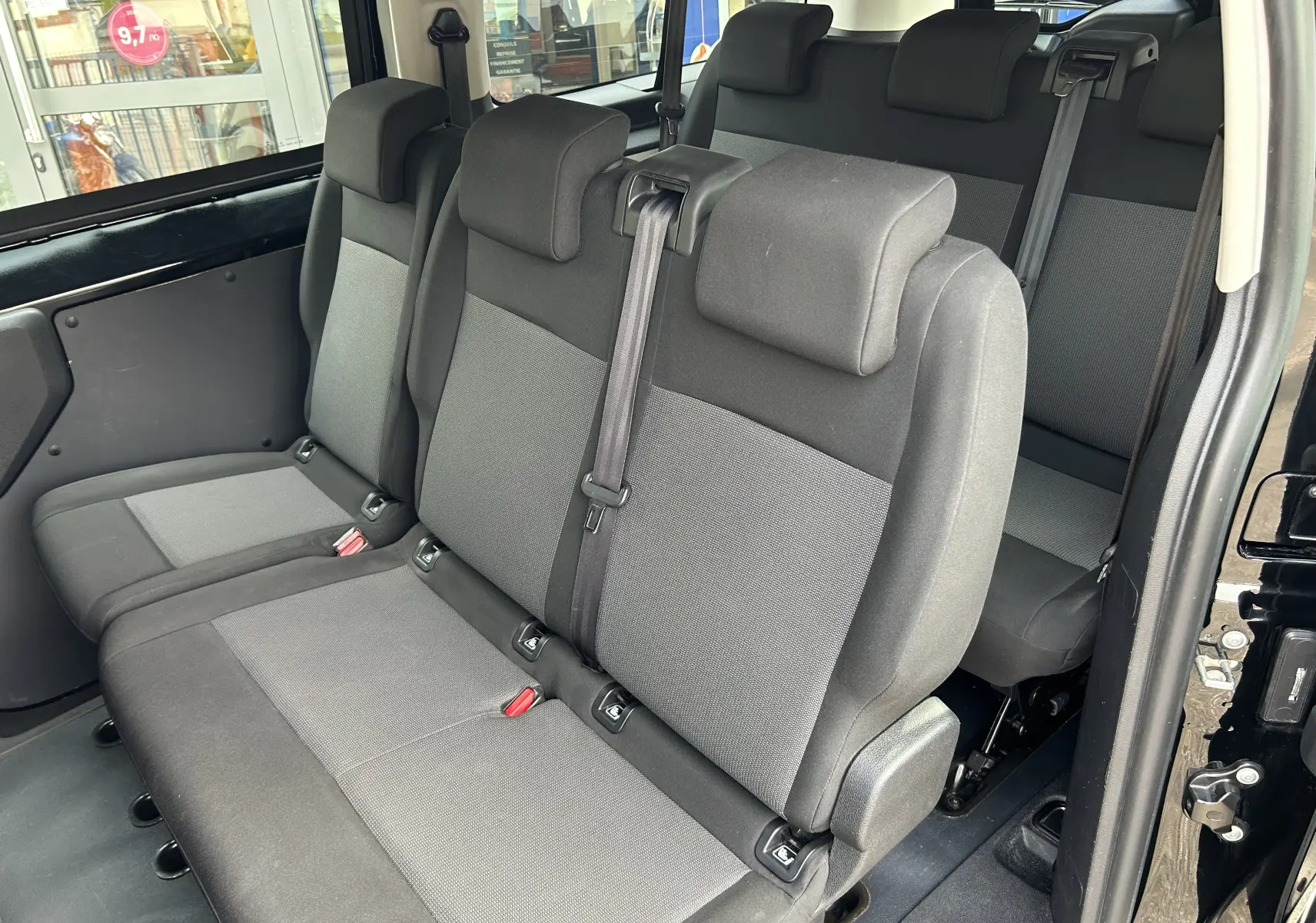 Vue intérieure côté droit des sièges tissu gris foncé de la deuxième rangée de l'Opel Vivaro Combi noir 2022.
