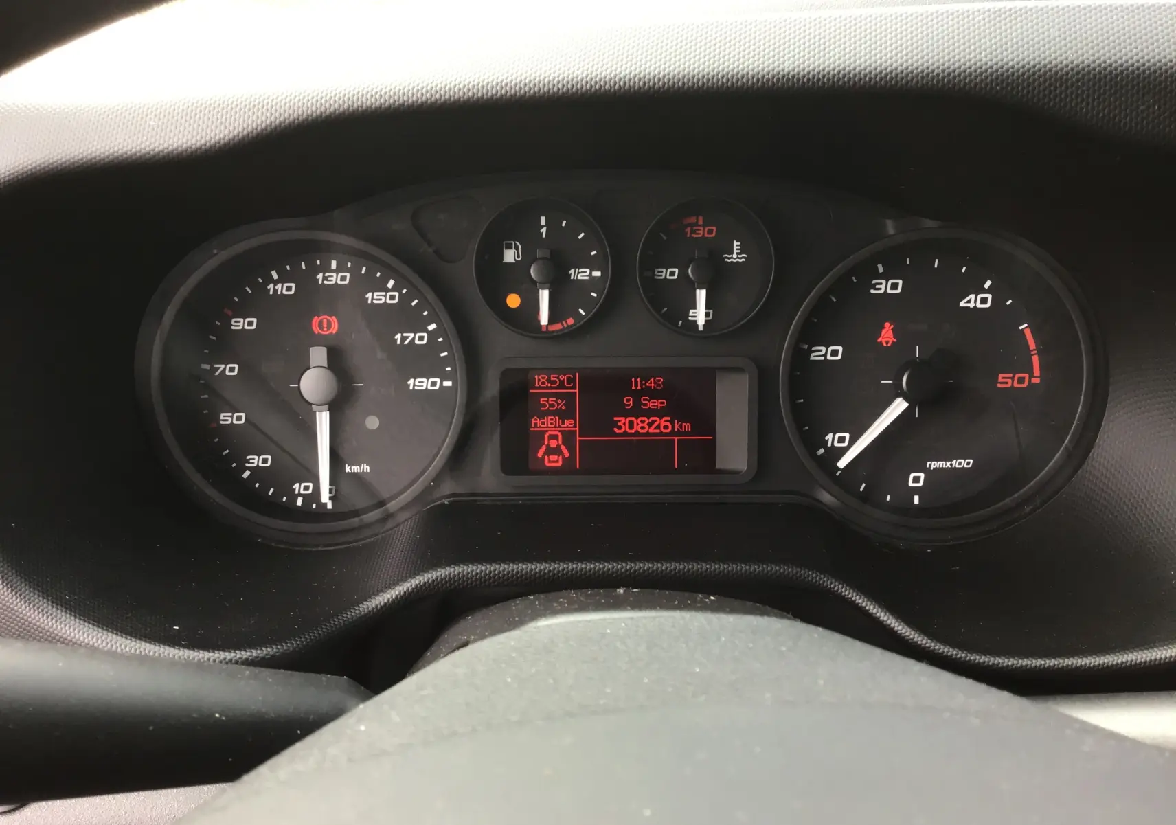 Vue rapprochée du tableau de bord du Iveco Daily 2022 avec affichage numérique et compteurs analogiques noirs.