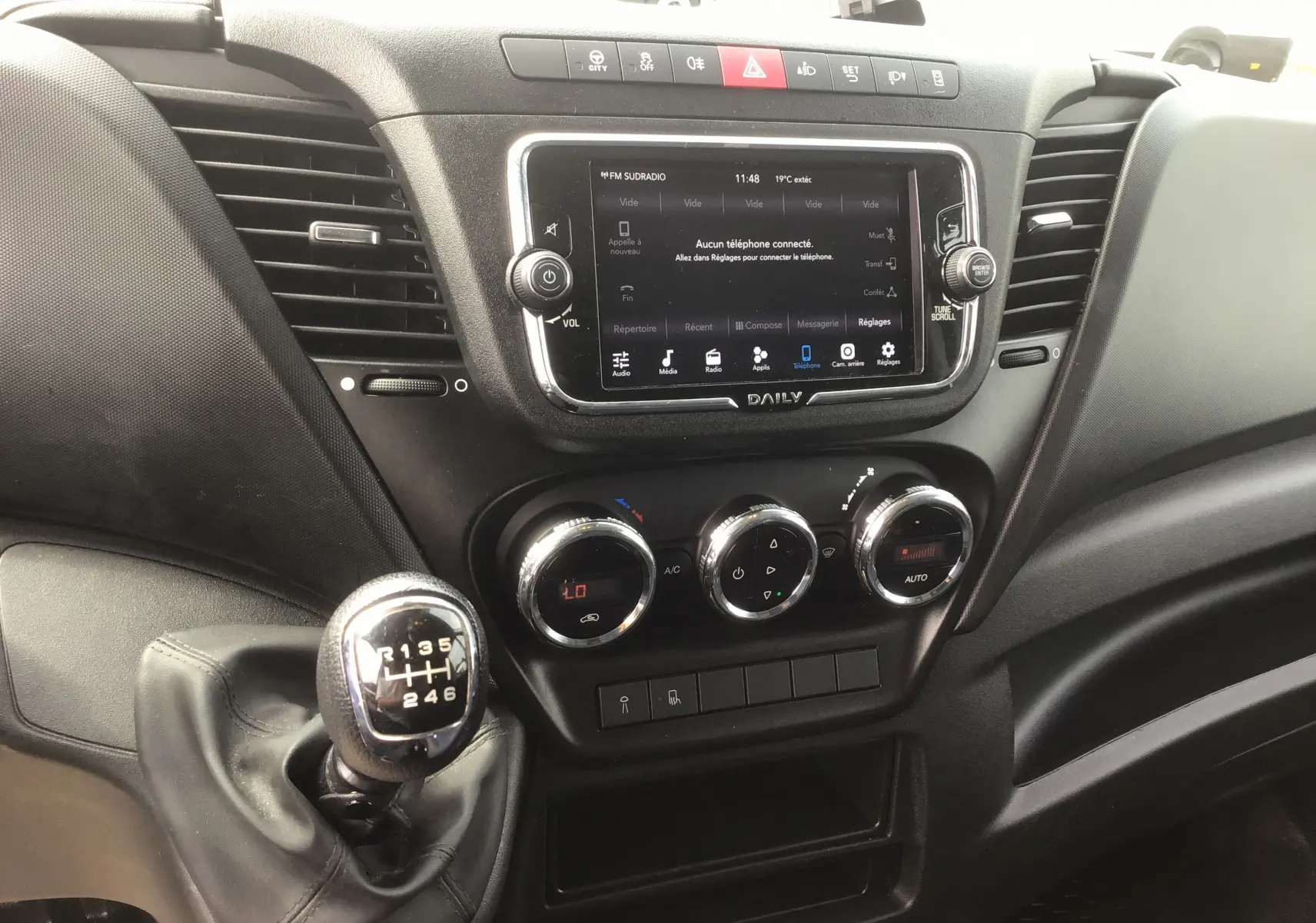 Intérieur du tableau de bord du Iveco Daily 2022, avec boîte manuelle et écran tactile central affichant les réglages.