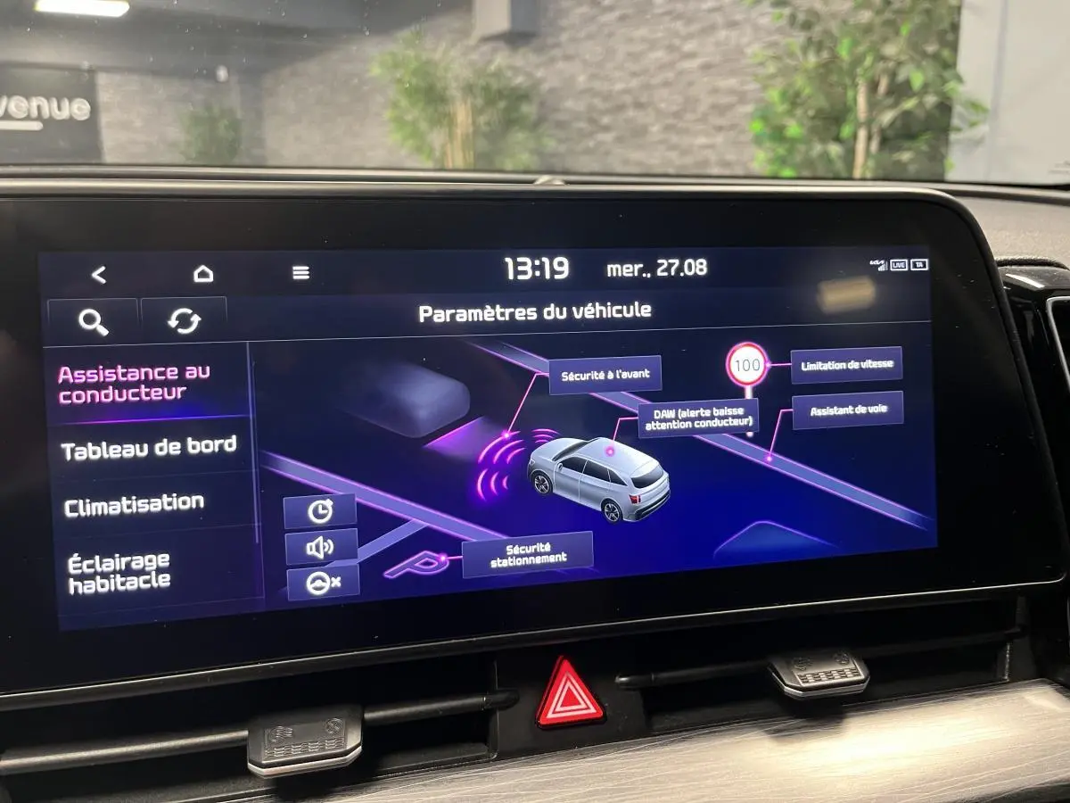Écran tactile intérieur du Kia Sportage blanc montrant les paramètres d'assistance au conducteur.