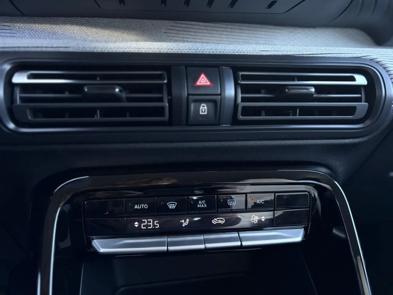 Détail de la console centrale avec commandes de climatisation et aérateurs noirs dans un Citroën C3 Aircross gris Mercury 2025.
